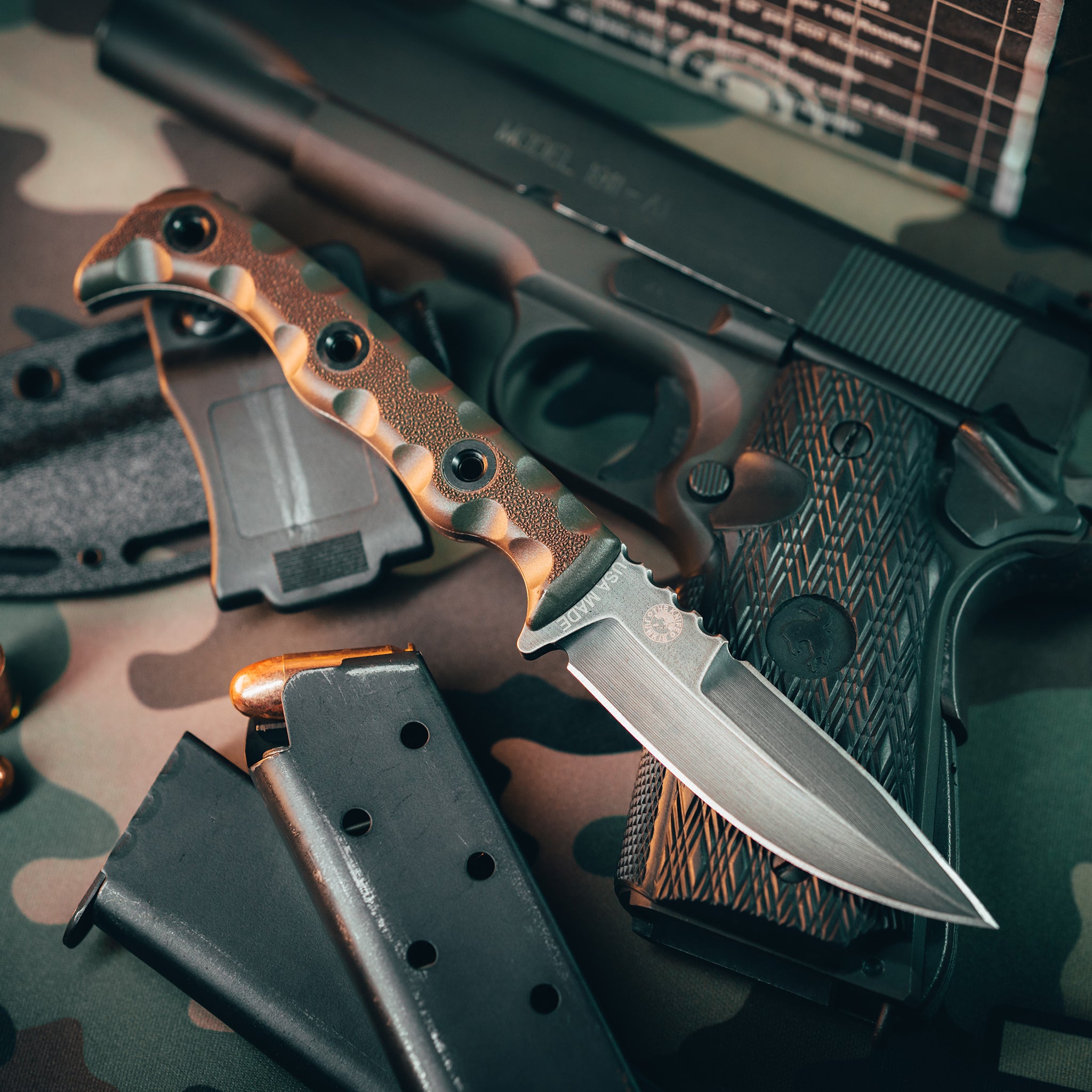 T.Kell AGENT 001 fixed blade tactical knife with tan battlelock grip resting on a black pistol